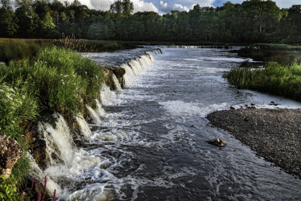The Ventas Rumba waterfall near Kuldiga with foaming water and surrounding greenery, Kuldiga, Courland, Latvia