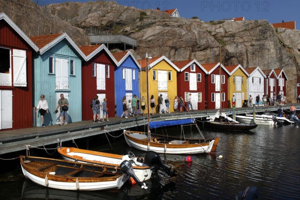 Lively harbor with colorful boathouses and boats situated on the waterfront, Smögen, Västra Götaland, Sweden