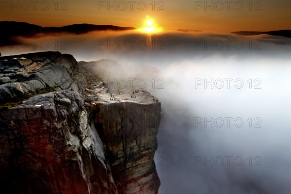 Sunrise over a sea of clouds illuminates the cliffs of Preikestolen, Preikestolen, Rogaland, Norway