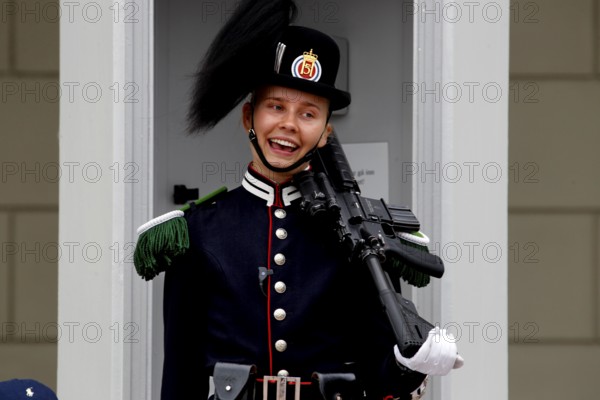 Smiling security guard in full uniform outside the Royal Palace in Oslo, Norway