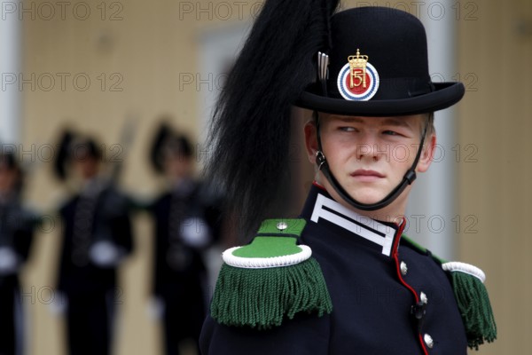 Norwegian security guard in decorative uniform wearing a hat decorated with feathers in front of the Royal Palace, Oslo, Norway