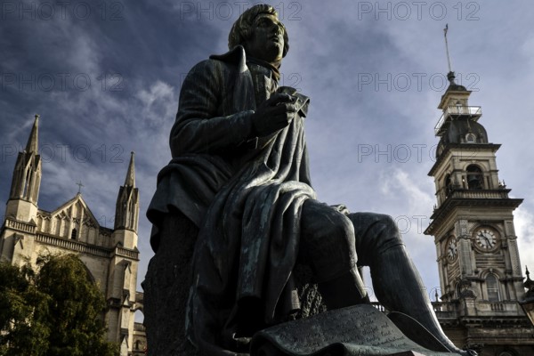 Robert Burns statue in front of historic backdrop with Gothic church tower in Dunedin, Dunedin, Otago, New Zealand