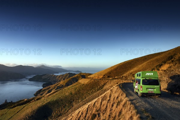 Camper drives along picturesque French Pass Road overlooking a sound, French Pass Road, South Island, New Zealand