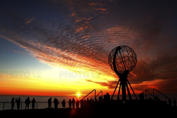 North Cape sunset with iconic globe and people in background, North Cape, Norway
