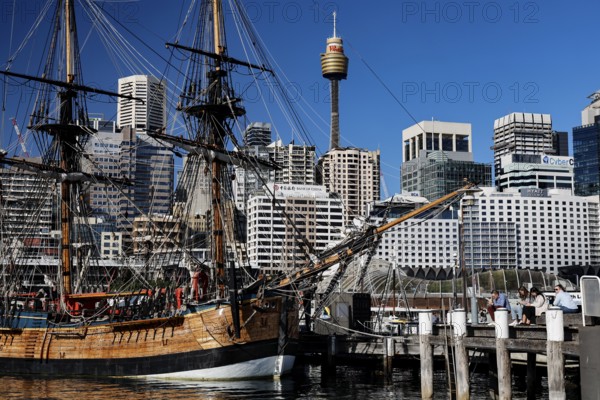 Historic sailing ship in Darling Harbour in front of a modern skyline under blue sky, Sydney, New South Wales, Australia