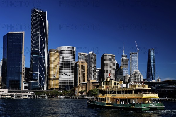 Sydney cityscape with passing ferry and skyscrapers in the background, Sydney, New South Wales, Australia