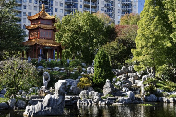 Temple surrounded by rocks and plants with city buildings in the background, Sydney, New South Wales, Australia