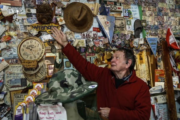 Person touches hat wall at Barrow Creek Hotel, Barrow Creek, Australia