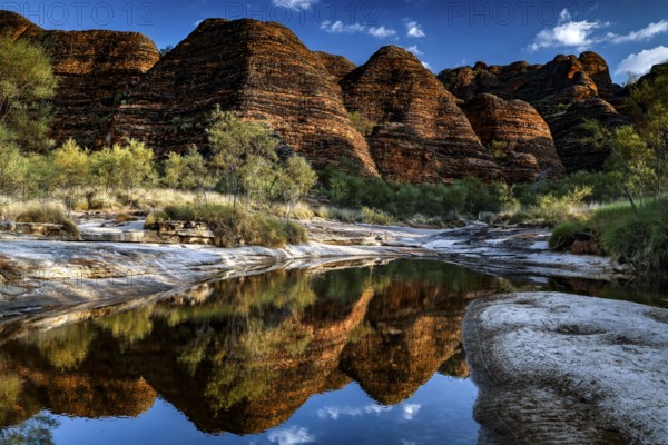 Dramatic rocky landscape reflected in the clear water of a waterhole, Purnululu National Park, Western Australia, Australia