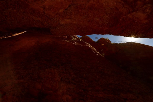 Light rays penetrate the tight, reddish brown Echidna Chasm, Purnululu, Western Australia, Australia