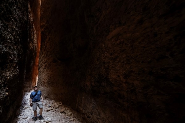 Hikers in the dark, impressive Echidna Chasm with narrow rock walls, Purnululu, Western Australia, Australia