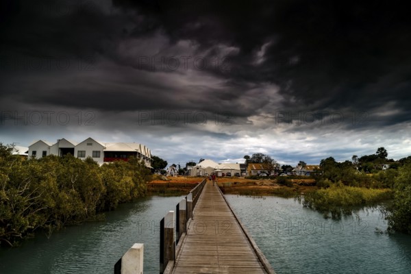 Streeters Jetty in Broome with dramatic clouds over coastal landscape, Broome, Western Australia, Australia