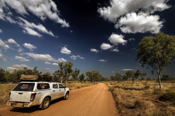 SUV on dusty road under dramatic sky in Purnululu National Park, Purnululu National Park, Western Australia, Australia