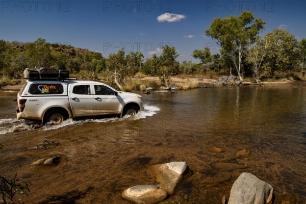 Vehicle crosses shallow river in remote area of Purnululu National Park, Purnululu National Park, Western Australia, Australia