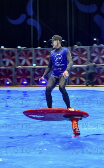 Press photo dynamic photo of eFoil surfer in the large XXL pool in Hall 17 of Messe Boot Düsseldorf, in the background the motto of Messe boot We Love Water, Messe Boot, Düsseldorf, North Rhine-Westphalia, Germany