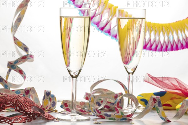 Two champagne glasses filled with colorful streamers, carnival