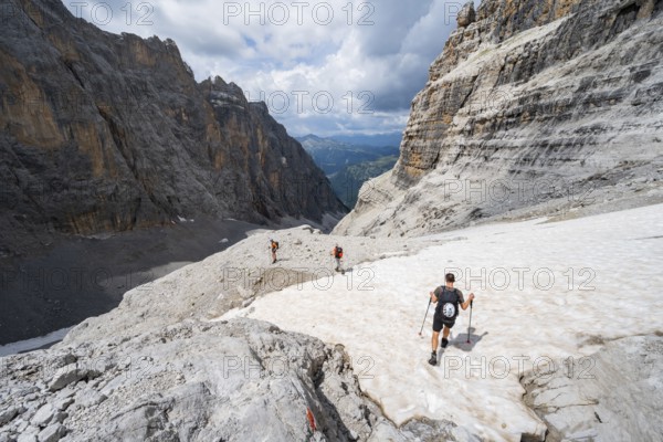 Three climbers descending the Sentiero Martinazzi, Camosci Valley, Brenta Mountains, Brenta-Adamello Natural Park, Trentino, Italy