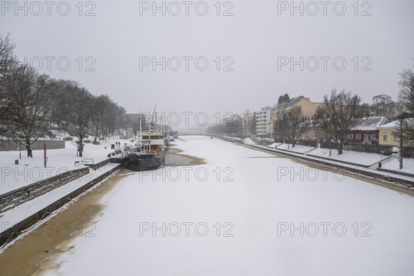 Ships moored on the banks of the frozen Aurajoki River, wintery Turku or Swedish Åbo, Varsinais-Suomi, Finland
