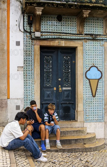 Young people eating ice cream, old town on Rue Padarias, Sintra, Lisbon, Portugal