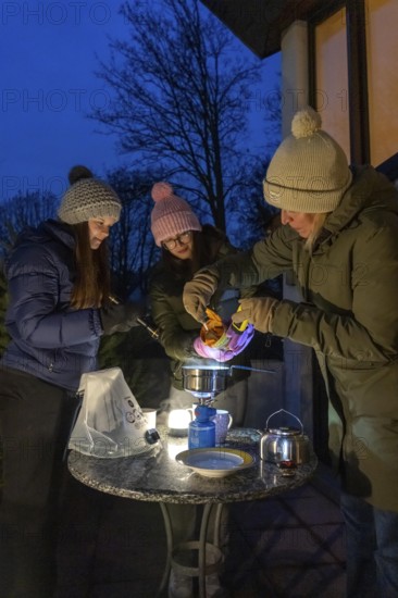 Symbolic picture blackout, extensive, prolonged power failure, in private surroundings, without electricity, heating, water, cooking, heating food and water with a gas-powered camping stove, on the balcony