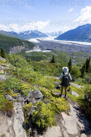 Young man enjoying the view, view of impressive mountain landscape with Matanuska glacier and glaciated mountain peaks, Lion's Head, Chugach Mountains, Alaska, USA