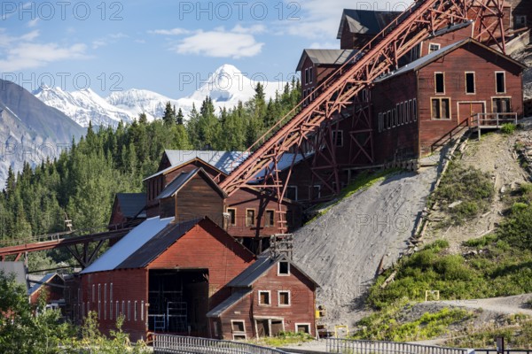 Red Kennicott buildings in front of mountainous landscape, Kennicott Concentration Mill to extract copper from quarried rock, Historic Kennecott Copper Mine, National Historic Landmark, Wrangell St. Elias National Park, Alaska, USA