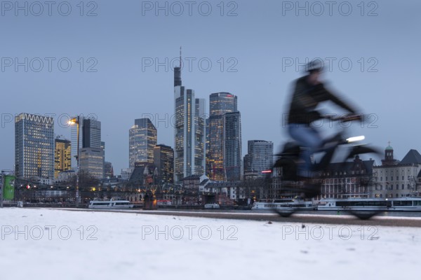 The towers of the Frankfurt banking skyline rise behind the snow-covered banks of the Main, Frankfurt am Main, Hesse, Germany