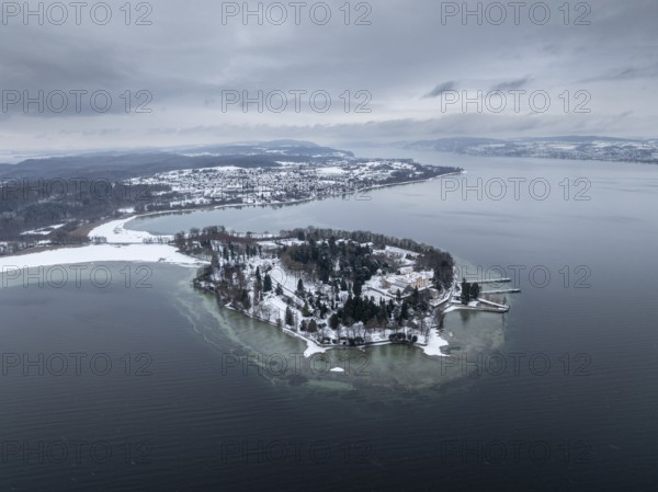 The wintry and snowy Mainau island in Lake Constance with the pier and the baroque Mainau Castle, built between 1739 and 1746, behind it the village of Litzelstetten, aerial view, district of Konstanz, Baden-Württemberg, Germany