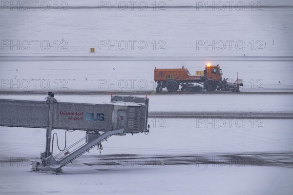 The onset of winter in North Rhine-Westphalia, flight operations are maintained at Düsseldorf airport with great effort, taxiways, runway are freed from snow and ice with many clearing vehicles, airplanes are de-iced in front of takeoff, North Rhine-Westphalia, Germany