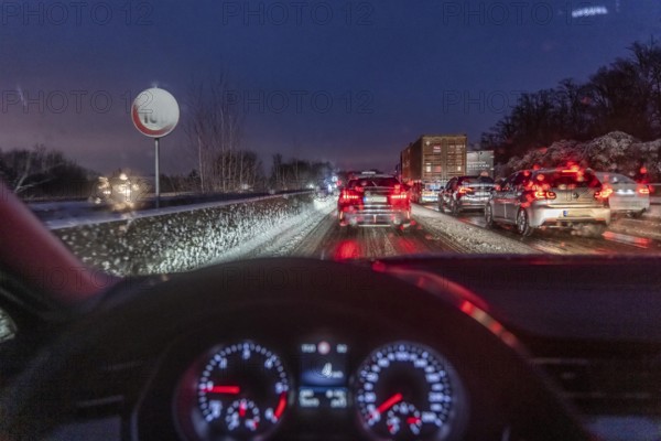 Driving in winter, in snow, motorway, rear lights, brake lights, speedometer, cockpit