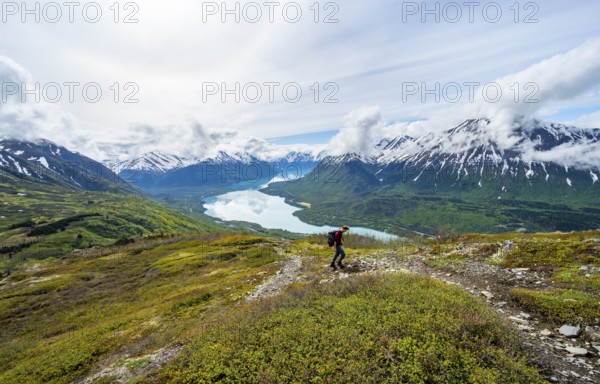 Climbers on a hiking trail, Slaughter Ridge Trail, view of snowy mountains and turquoise lake Kenai Lake, Cooper Landing, Kenai Peninsula, Alaska, USA