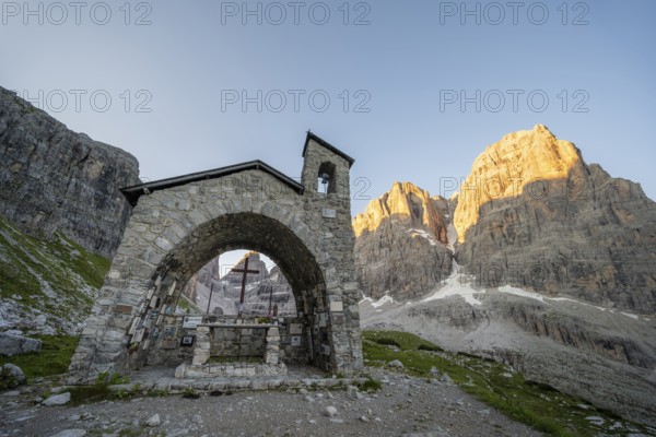 Cappella Ai Brentei chapel Memorial for injured mountaineers at the Rifugio Ai Brentei mountain hut, rocky peaks at sunrise with alpine glow, picturesque mountain landscape, Brenta, Trentino, Italy