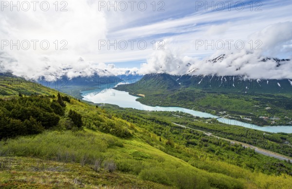 View of snowy mountains in spring and turquoise blue Kenai Lake, Slaughter Ridge Trail, Cooper Landing, Kenai Peninsula, Alaska, USA