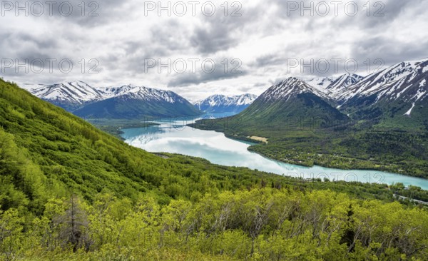 View of snowy mountains in spring and turquoise blue Kenai Lake, Slaughter Ridge Trail, Cooper Landing, Kenai Peninsula, Alaska, USA