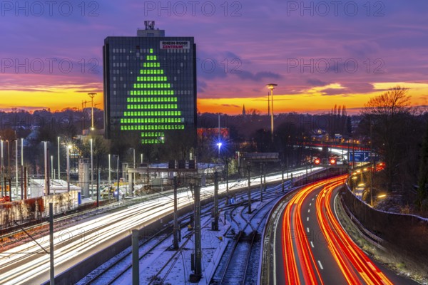 Autobahn A40, Ruhrschnellweg, between Essen and Mülheim an der Ruhr, evening traffic in winter, former, now vacant Stinnes high-rise building, at the Rhine-Ruhr Center, showing a green Christmas tree from illuminated windows at Christmas time, North Rhine-Westphalia, Germany
