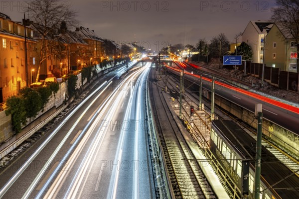 Autobahn A40, Ruhrschnellweg, near Essen at the Frohnhausen junction, evening traffic in winter, residential buildings directly on the 4-lane motorway, North Rhine-Westphalia, Germany