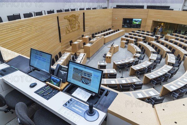 Plenary hall deserted with the seats of deputies and the government bank. Behind it is the country's coat of arms. The speaking time of members of the parties is recorded and documented down to the second. The state parliament of Baden-Württemberg is the state parliament based in Stuttgart, Baden-Württemberg, Germany