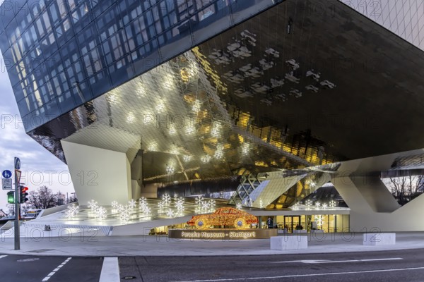 Highlights on Porscheplatz in Zuffenhausen. In front of the Porsche Museum and the car manufacturer's headquarters, a 911 sports car shines in Christmassy splendor. Stuttgart, Baden-Württemberg, Germany