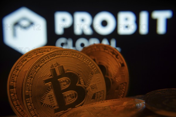 Dhaka, Bangladesh- 27 Mar 2025: Close-up of Bitcoin coins with the ProBit Global logo visible on a screen in the background