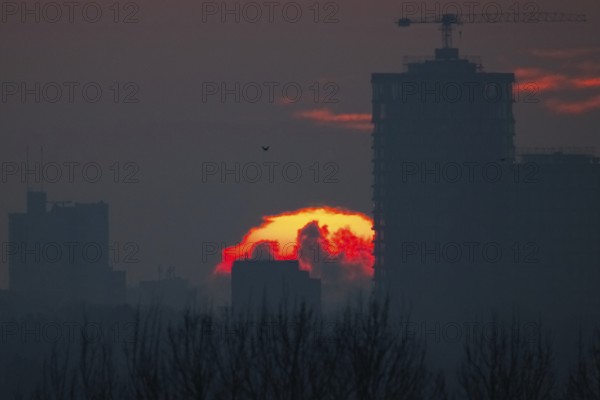 The sun rises behind Frankfurt's banking skyline, Frankfurt am Main, Hesse, Germany