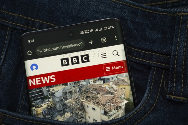 Dhaka, Bangladesh- 15 June 2025: A smartphone displaying the BBC web interface peeks out of a denim pocket