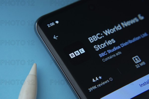 Dhaka, Bangladesh- 29 May 2025: On a blue surface, a smartphone displays the BBC app within the Google Play Store