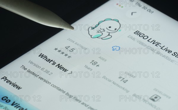 Dhaka, Bangladesh- 30 Oct 2025: Bigo Live app on a iPad screen with a pen pointing at the install option