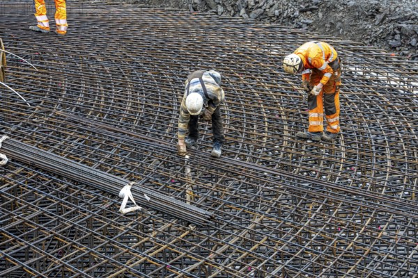 Assembly of reinforcing steel for the reinforced concrete foundation of a wind turbine, a mesh of rebar and reinforcing steel mesh, connecting the steel elements with binding wire, twisting with tongs, over 100 tons of reinforcing steel were used, the wind turbine will have a hub height of 160 meters, part of a new wind farm in Sauerland, near Balve, North Rhine-Westphalia, Germany