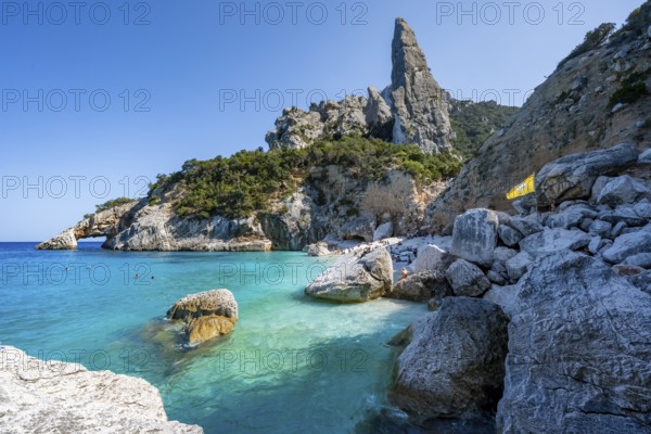 Light blue clear sea on a dream beach on Cala Goloritzé, picturesque rocky coast, steep coast with rock pin L'Aguglia, Golfo di Orosei, Baunei, Sardinia, Italy
