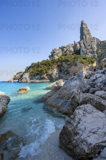 Light blue clear sea on a dream beach on Cala Goloritzé, picturesque rocky coast, steep coast with rock pin L'Aguglia, Golfo di Orosei, Baunei, Sardinia, Italy
