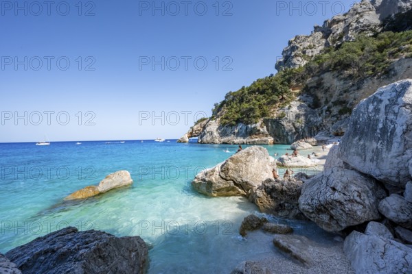 Light blue clear sea on a dream beach on Cala Goloritzé, picturesque rocky coast, cliffs with rock arch, Golfo di Orosei, Baunei, Sardinia, Italy