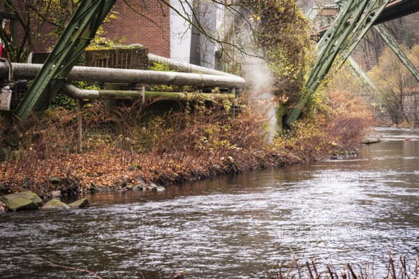 District heating pipeline in front of old industrial buildings on the banks of the Wupper, Wuppertal, Germany