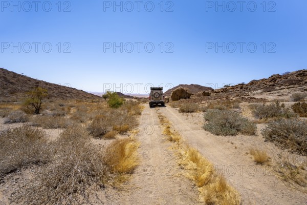 Toyota Hilux off-road vehicle on a sandy track, desert landscape with Brandberg, Erongo, Damaraland, Namibia