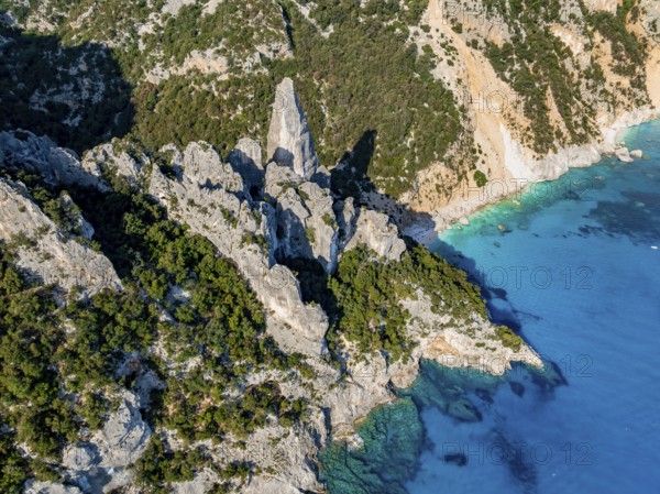 Picturesque rocky coast, cliffs with L'Aguglia pinnacle, blue sea and Cala Goloritzé beach, aerial view, Golfo di Orosei, Baunei, Sardinia, Italy